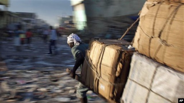 A man pulls a cart with merchandise past quake-damaged buildings in downtown Port-au-Prince, Haiti, 06 Jan 2011