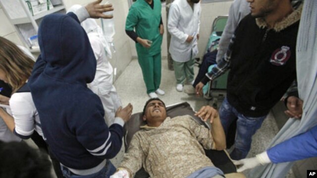 A wounded man is carried into the al-Jala hospital in Benghazi after an attack by Libyan military forces loyal to Muammar Gaddafi on a weapons dump near Benghazi in rebel-controlled eastern Libya killed 17 people, Al Jazeera television reported, March 4, 
