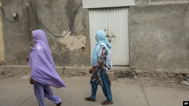 Local women walk past locked house of Christian girl in a suburb of Islamabad, Aug. 20, 2012.