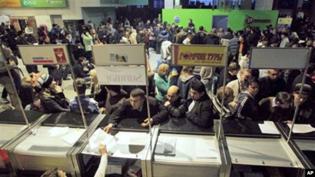 With Moscow's Domodedovo Airport temporarily shut down due to icy rain passengers queue in front of ticket and information counters Sunday, 26 Dec 2010