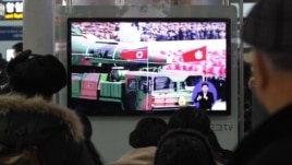 People watch a TV news showing file footage of a North Korean rocket carried during a military parade, at Seoul Railway Station in Seoul, South Korea, January 24, 2013.
