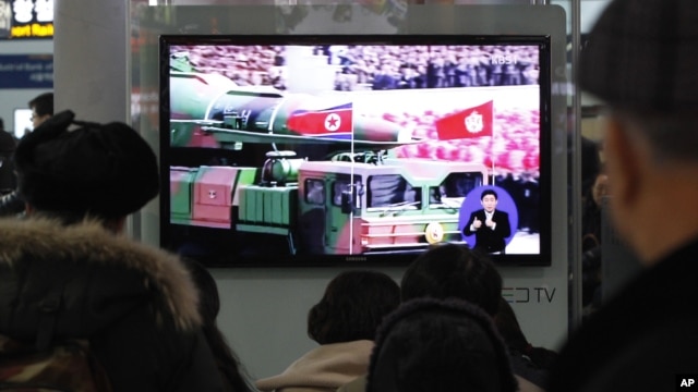 People watch a TV news showing file footage of a North Korean rocket carried during a military parade, at Seoul Railway Station in Seoul, South Korea, January 24, 2013.