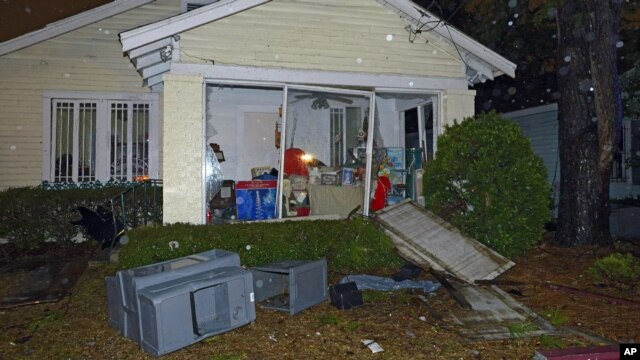 A home is damaged and its lawn is covered with debris after a tornado touched down in Mobile, Alabama, December 25, 2012.
