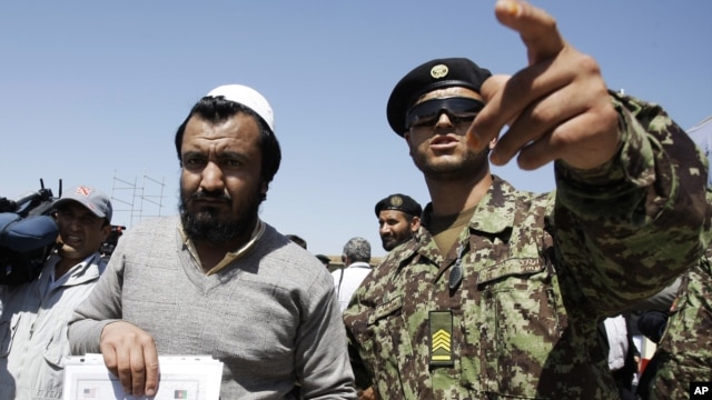 An Afghan soldier, right, escorts a released prisoner, Mohammad Karim, following a hand over ceremony of U.S.- run prison to Afghan government in Bagram north of Kabul, Afghanistan, Sept. 10, 2012. 