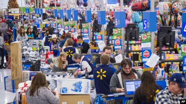 FILE - Sales clerks ring up customers at Walmart in Bentonville, Arkansas.