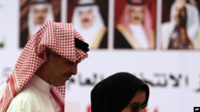 A Bahraini couple cast ballots Saturday, Oct. 23, 2010, at a general polling station set up on the Bahrain side of a bridge connecting Bahrain and Saudi Arabia. After months of street unrest, voters in the island kingdom of Bahrain were choosing a new par