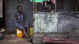Women sit on the porch of a house in the Congo Town neighborhood of Sierra Leone's capital Freetown, April 28, 2012. 