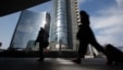 FILE - People walk in the Porta Nuova business center in Milan, Italy, March 11, 2016. 
