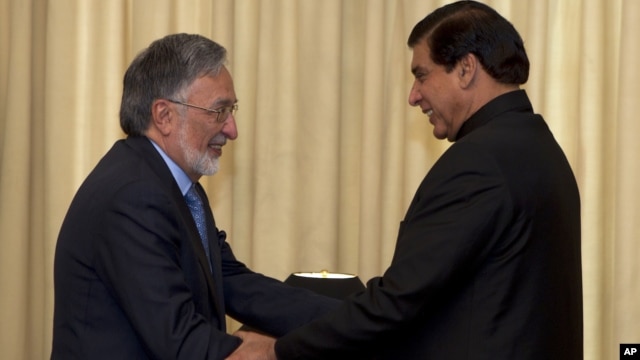 Afghan Foreign Minister Zalmay Rasoul, left, shakes hands with Pakistan's Prime Minister Raja Pervaiz Ashraf in Islamabad, Pakistan, November 30, 2012.