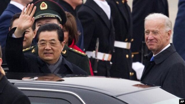 Chinese President Hu Jintao, accompanied by Vice President Joe Biden, waves during the arrival ceremony, Tuesday, Jan. 18, 2011, at Andrews Air Force Base, outside Washington.