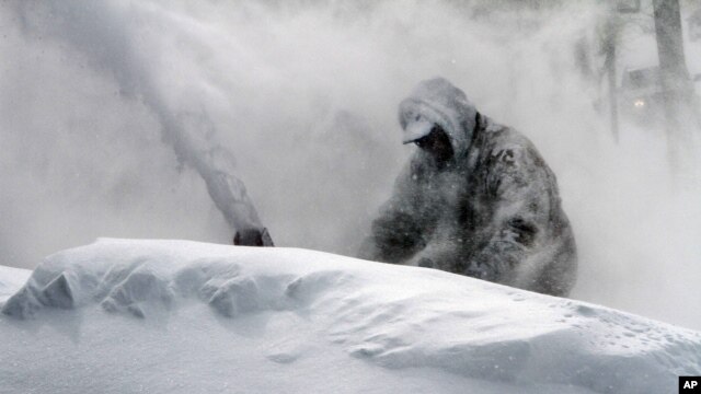 Neil Hodges uses a snow blower to clear drifting snow from in front of his home in Concord, N.H. on Saturday, Feb. 9, 2013.