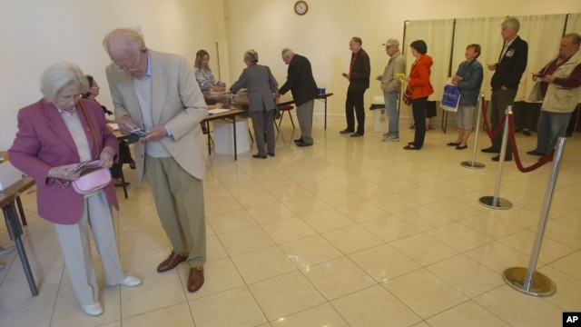 French citizens line up to vote during legislative election in Louveciennes , 12 kms ( 7.5 mls) west of Paris, June 17, 2012.