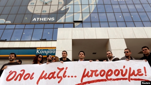 Employees of the Bank of Cyprus take part in a rally, in solidarity with crisis-hit Cypriots, outside the headquarters of the bank in Athens, Greece, Mar. 20, 2013. 