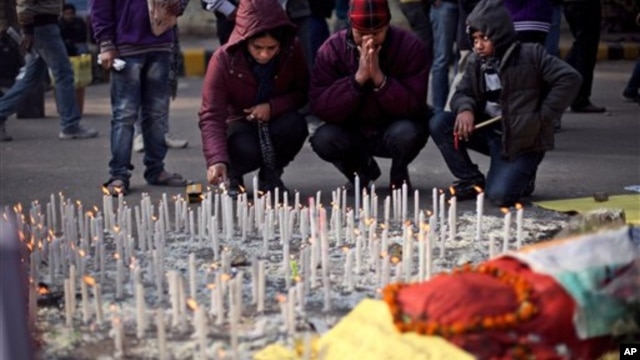 Satu keluarga India menyalakan lilin untuk mengenang perempuan korban perkosaan beramai-ramai di New Delhi bulan lalu, hari Sabtu (5/1).