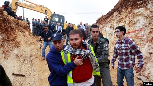 A plainclothes Israeli policeman (L) detains a Palestinian protester during a demonstration against Israel's construction of a road in the Arab neighborhood of Beit Safafa in Jerusalem, February 10, 2013.