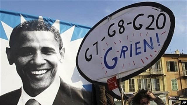 Demonstrators walk past of poster of U.S. President Barack Obama with a placard reading 'G7-G8-G20-I have nothing' during a protest in Nice, southern France, Nov. 1, 2011.
