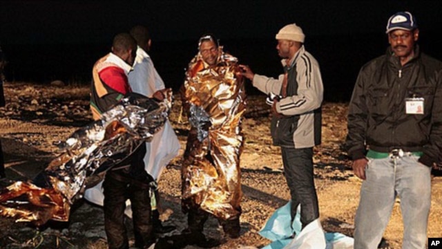 Migrants receive assistance as they arrive on the tiny island of Lampedusa, Italy, early Sunday, May 8, 2011