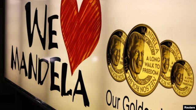 A banner advertises gold coins with the image of former South African President Nelson Mandela, Johannesburg, December 9, 2012. 