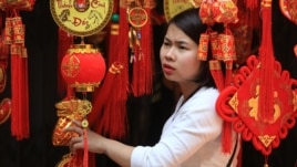 Hình minh họa: Một người phụ nữ đang xem những đèn lồng trang trí ngày Tết ở phố cổ Hà Nội.