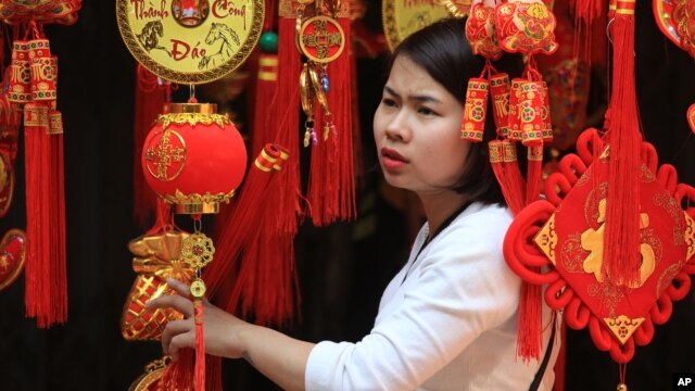 Hình minh họa: Một người phụ nữ đang xem những đèn lồng trang trí ngày Tết ở phố cổ Hà Nội.