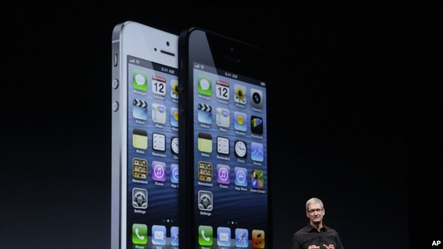 Apple CEO Tim Cook speaks in front of an image of the iPhone 5 during an Apple event in San Francisco, Sept. 12, 2012.