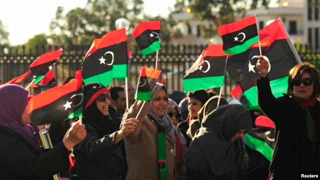 Perempuan Libya ikut berpawai keliling kota dengan membawa bendera negaranya dalam perayaan dua tahun revolusi di Benghazi, 17 Februari 2013. (REUTERS/Esam Al-Fetori).