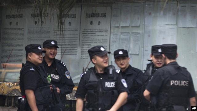 Chinese policemen huddle near the Chengdu Intermediate People's Court in Chengdu in southwest China's Sichuan province, Sept. 17, 2012.