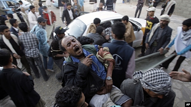 Protestors carry an injured man from the site of clashes with security forces in Sana'a, Yemen, December 24, 2011.