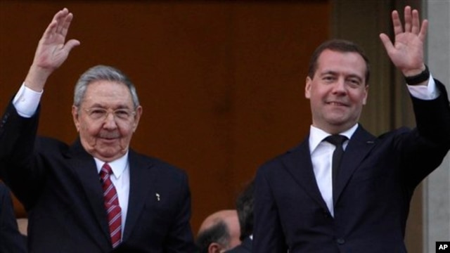 Presiden Kuba Raul Castro (kiri) dan Perdana Menteri Rusia Dmitry Medvedev melambaikan tangannya kepada para wartawan seusai meletakkan karangan bunga di monumen Jose Marti di Havana, Kuba (21/2). 