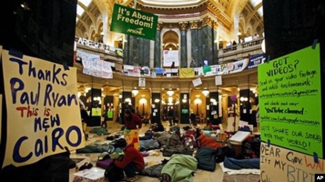 Opponents to the governor's bill to eliminate collective bargaining rights for many state workers sleep on the floor of the rotunda at the state Capitol in Madison, Wisconsin, at the start of the tenth day of protests, February 24, 2011