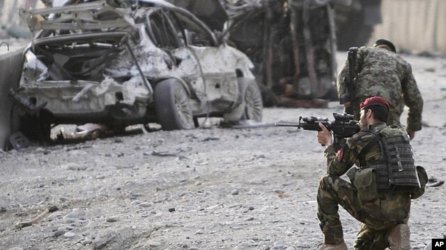 An Afghan soldier secures the scene of a suicide attack at the gate of an airport in Jalalabad, Nangarhar province east of Kabul, Afghanistan, Feb. 27, 2012. 