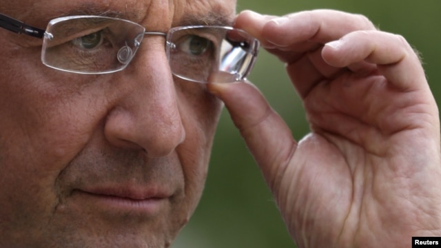 France's President Francois Hollande adjusts his glasses after a meeting at the Elysee Palace in Paris, September 20, 2012.