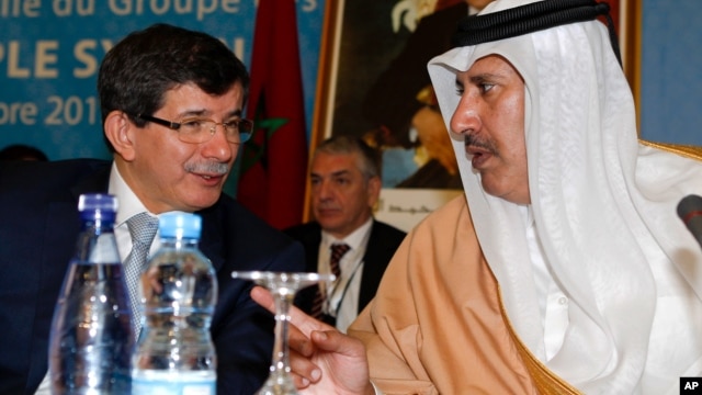 Turkish Foreign Minister Ahmet Davutoglu, left, chats with Qatar's Prime Minister and Foreign Minister Sheik Hamad bin Jassim al-Thani at a meeting of the Friends of the Syrian People in Marrakech, Morocco, Wednesday, Dec. 12, 2012.