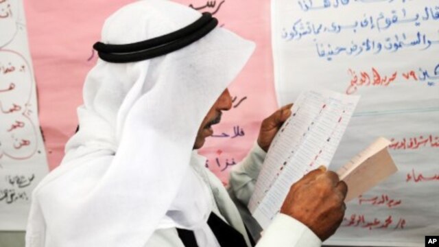 An Egyptian man reads a ballot form preparing to vote at a polling station in El Arish, in the northern part of Egypt's Sinai Peninsula, January 3, 2012.