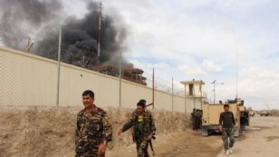 FILE - Smoke rises from a building, where Taliban insurgents hide during a firefight with Afghan security forces, in Helmand province, southwest Afghanistan, March 9, 2016.