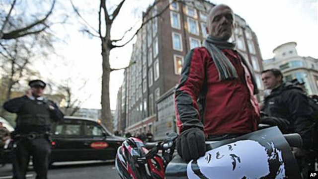 A supporter of Wikileaks founder Julian Assange, holding a poster with his picture outside the City of Westminster Magistrates Court in London where Assange's case was heard, Dec 7, 2010