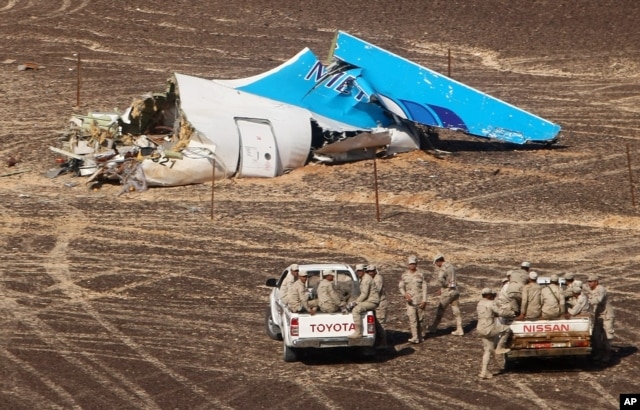 In this photo made available Nov. 2, 2015, and provided by Russian Emergency Situations Ministry, Egyptian military forces approach a plane's tail at the wreckage of a passenger jet bound for St. Petersburg in Russia that crashed in Hassana, Egypt, Nov. 1.