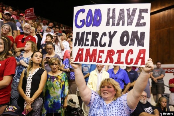 A supporter holds up a sign as Republican presidential nominee Donald Trump speaks during a campaign rally in Sarasota, Florida, U.S. Nov. 7, 2016.