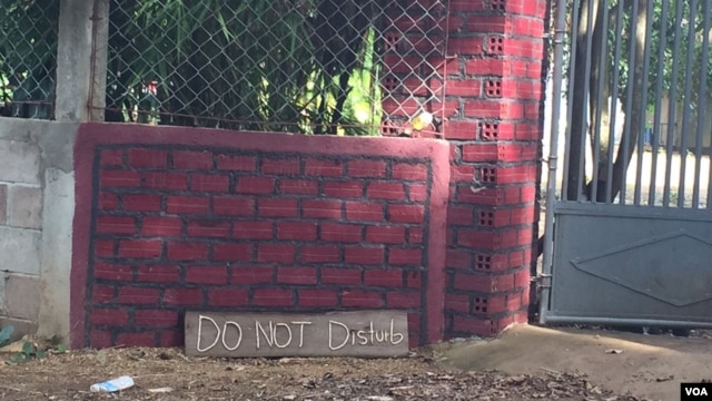 A sign in English says “Do Not Disturb” outside of Meas Muth's home in Samlot district, Battambang province, August 12, 2015. (Photo: Sok Khemara/VOA Khmer)