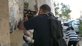 An armed militiaman stands behind a barricade of sandbags in Tripoli's Sunni Muslim neighborhood of Bab al-Tabbaneh June 2, 2012. 