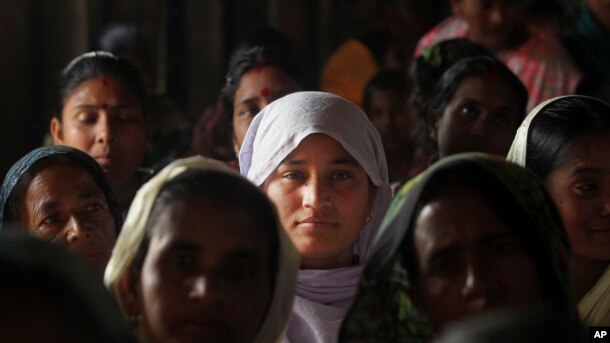 FILE - Migrant Muslim women are seen at a health mission in Baralakhaiti village, about 70 kilometers (43 miles) north of Gauhati, Assam State, India, Feb. 10, 2014.