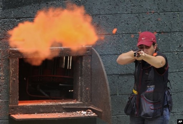 FILE - Olympic skeet shooter Kim Rhode hits a clay pigeon as she practices at Oak Tree Gun Club, in Newhall, California, June 8, 2011.