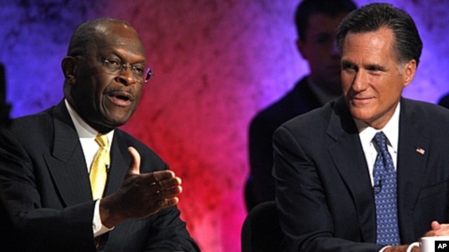 Republican presidential candidate and businessman Herman Cain (l) speaks as former Massachusetts Governor Mitt Romney listens during a Republican presidential debate at Dartmouth College in Hanover, New Hampshire, October 11, 2011.