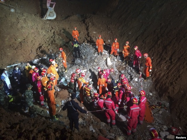 Rescuers surround the area where they found a 19-year-old survivor under a collapsed building at the site of a landslide which hit an industrial park on Sunday, in Shenzhen, Guangdong province, Dec. 23, 2015.