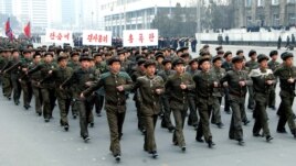 North Korean students attend a contest of singing wartime songs in chorus while marching in array, at Kim Il Sung square in Pyongyang in this picture released by the North's KCNA news agency March 17, 2013.