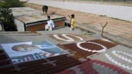 People display portraits of U.S. President Barack Obama on the roof of their houses near Phnom Penh Airport November 14, 2012. Around 182 families living around the airport have been served with eviction notices ahead of Obama's historic visit to the country.