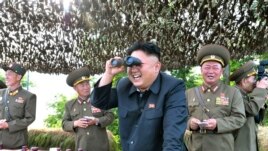 Lãnh tụ Bắc Triều Tiên Kim Jong Un dùng ống nhòm quan sát trận địa với các tướng lãnh.