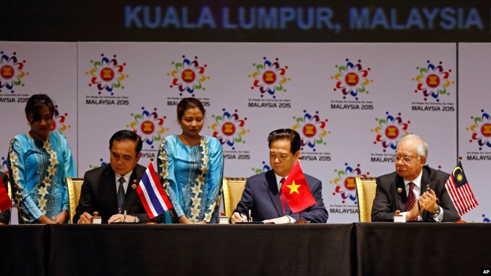 Thai Prime Minister Prayuth Chan-ocha, left, and Vietnam's Prime Minister Nguyen Tan Dung, center, sign documents as Malaysia's Prime Minister Najib Razak looks on during the signing ceremony of the 2015 Kuala Lumpur Declaration on the Establishment of the ASEAN Community and the Kuala Lumpur Declaration on ASEAN 2025, in Kuala Lumpur, Malaysia, Nov. 22, 2015.