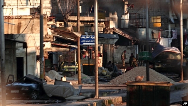 Soldiers of the government forces are seen outside a building in Attarib, Aleppo province, Syria, March 1, 2012.