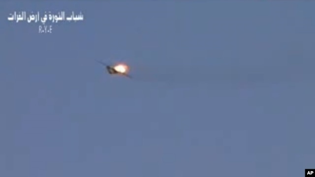 This image made from amateur video released by R.Y.E. Syria purports to show a Syrian plane downed over the eastern province of Deir el-Zour, Syria, August 13, 2012. 